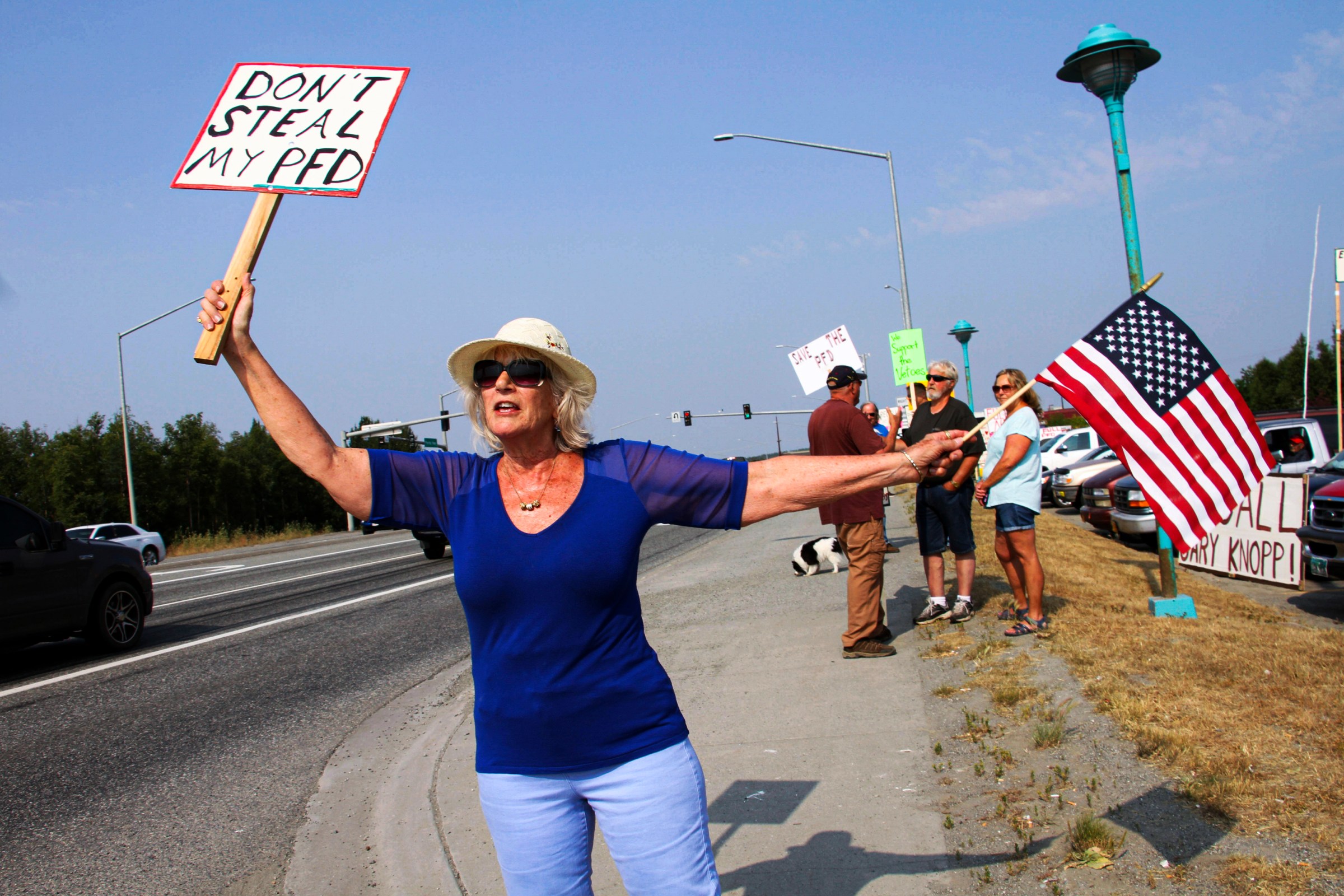 Katherine Hayes demonstrates urging Alaska lawmakers to fund a full oil wealth fund check, known locally as the PFD or Permanent Fund Dividend, on July 8, 2019, in Wasilla, Alaska.