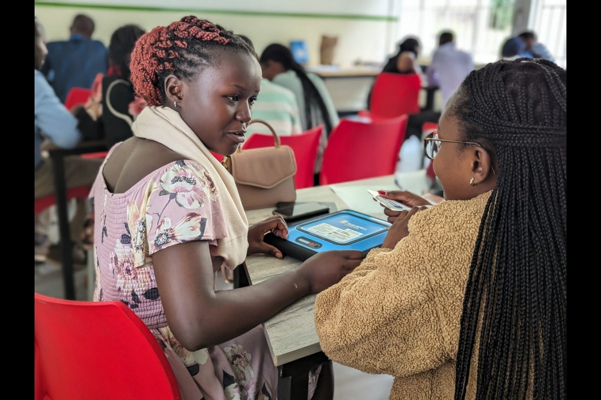 People in a classroom in Africa interact with a tablet